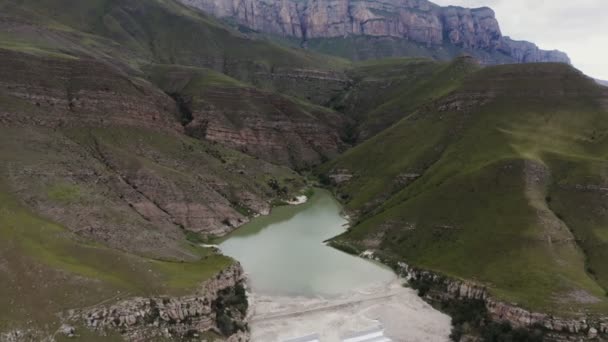 녹색 언덕 들 사이에 있는, 불규칙 한 모양의 맑은 산 호수의 모습 — 비디오