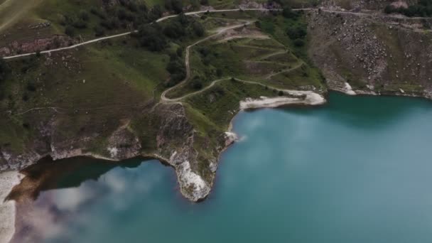 Una veduta di chiaro lago di montagna di forma irregolare situato tra verdi colline — Video Stock