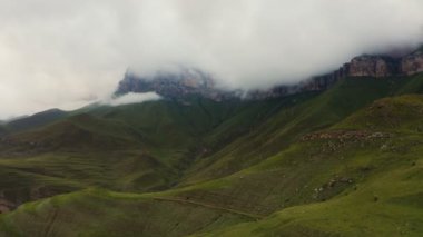 Dağlık vadi, yumuşak tepeler otlar ve kayalık kayalıklarla kaplı.