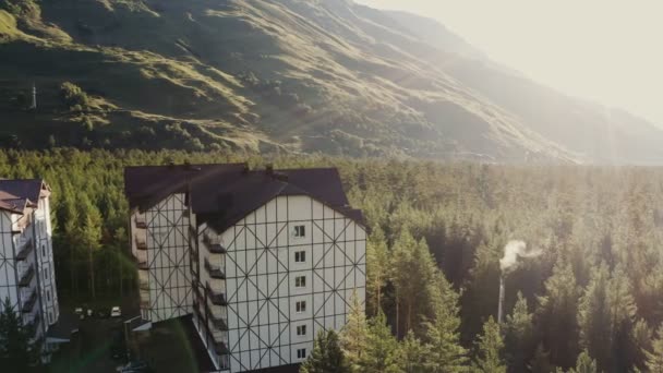 Vista de um complexo hoteleiro de vários andares nas terras baixas de um vale montanhoso — Vídeo de Stock