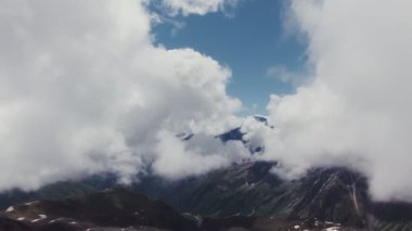 Elbrus Dağı 'nın karla kaplı zirvesi kalın bulutların arasından görünüyor.