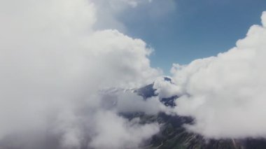Elbrus Dağı 'nın karla kaplı zirvesi kalın bulutların arasından görünüyor.