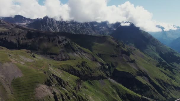 Una vista de las laderas de la montaña con hierba verde, al pie de las montañas rocosas — Vídeo de stock
