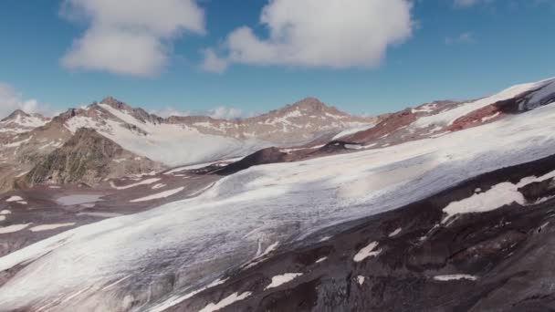 Prudké skalnaté hory s útesy a římsami, pokryté sněhem a mraky — Stock video