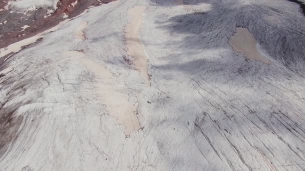 Vista superior de la suave ladera rocosa cubierta de nieve. Vista aérea del monte Elbrus — Vídeo de stock