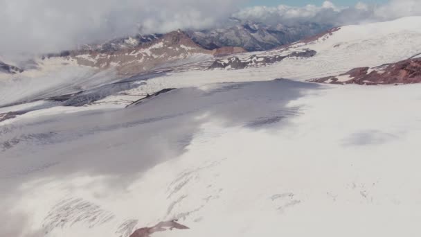 Horní pohled na mírný skalnatý, zasněžený svah. Letecký pohled Mount Elbrus — Stock video