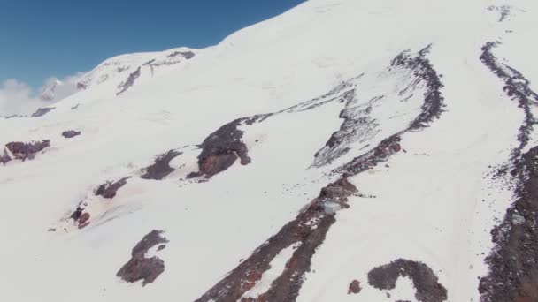 Zasněžený vrchol hory Elbrus s vykukujícími skalnatými římsami — Stock video