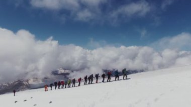 Rusya, Kafkasya, Elbrus. Tırmanışçılar karla kaplı bir yamaç boyunca tırmanırlar.