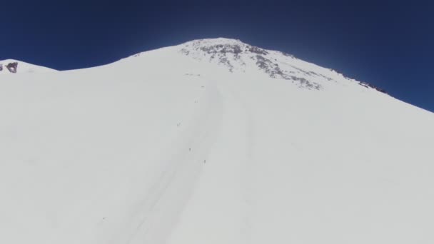 Pico coberto de neve do Monte Elbrus com encostas suaves com pistas de esqui e turistas — Vídeo de Stock