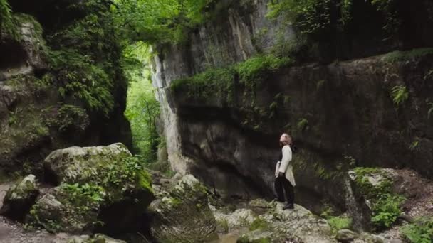 美丽的年轻女子站在高山低洼地的一块大石头上 — 图库视频影像
