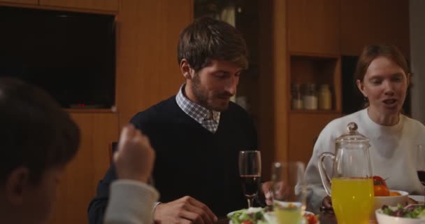 Una familia está comiendo una cena festiva y hablando entre sí, en Acción de Gracias — Vídeos de Stock