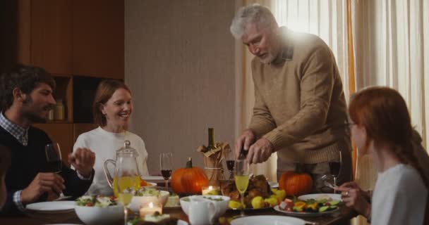 Familienvater schneidet Truthahn und verteilt Stück zu Thanksgiving an alle — Stockvideo