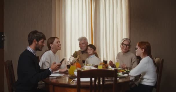Uma família tira selfie no telefone sentado em uma mesa festiva colocada, no Dia de Ação de Graças — Vídeo de Stock