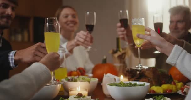 A family clink glasses, sitting at set festive table in Thanksgiving — Stock Video