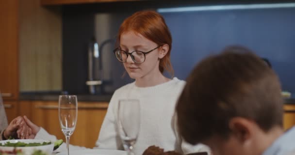 The family joins hands for prayer before the family dinner — Stock Video