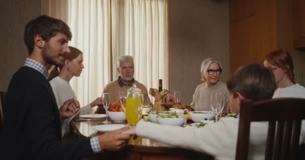 La familia se une a la oración antes de la cena familiar — Vídeo de stock