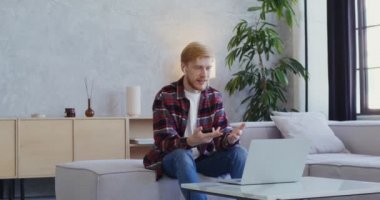 Kulaklıklı yakışıklı adam gülümsüyor, bilgisayardan video görüşmesi yapıyor.
