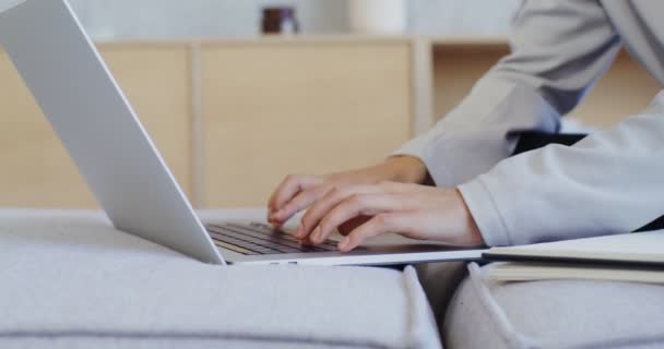 Kobieta pisząca na laptopie i notująca długopisem w notatniku — Wideo stockowe