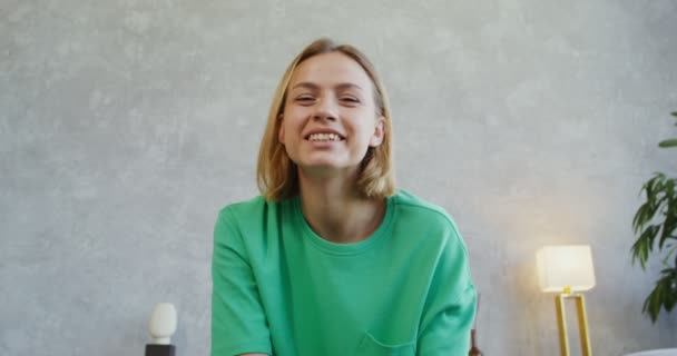 Una giovane donna che parla in videochiamata guardando la macchina fotografica, riprese frontali — Video Stock