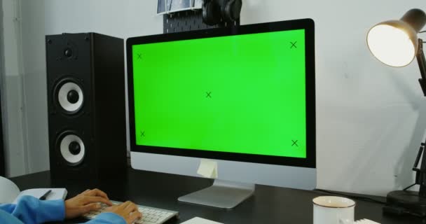 Una joven vestida con ropa casual usa una computadora mientras trabaja desde casa — Vídeos de Stock
