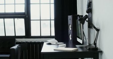 Gündelik giysiler içinde genç bir adam bilgisayara yaklaşıyor, oturuyor ve çalışmaya başlıyor.