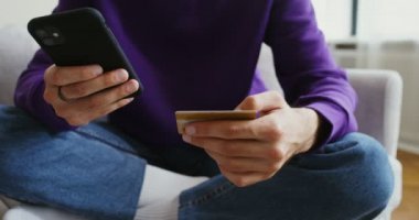 Adamın biri telefon üzerinden satın almak için kart detaylarını giriyor.