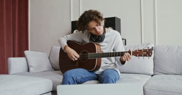 Facet oglądający poradnik gitary na laptopie i uczący się gry na instrumencie — Wideo stockowe