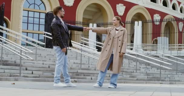 Genç bir çift şehrin sonbahar caddesinde dans edip öpüşüyor. — Stok video