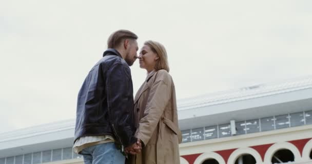 A young couple is walking along the parapet holding hands and stopping for kiss — Stock Video