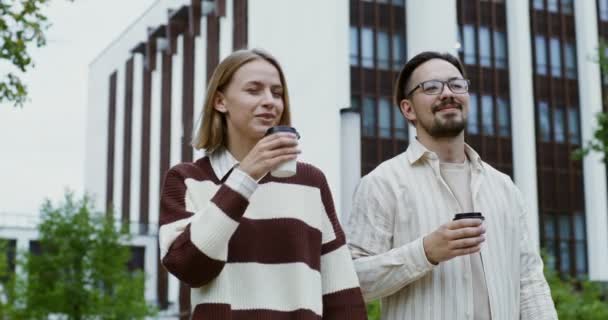 Jeune couple marchant autour de la ville boire du café et parler — Video