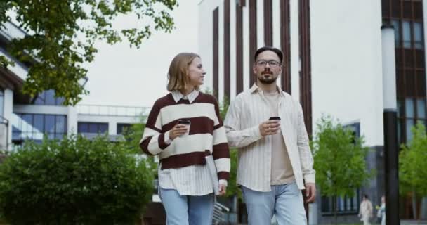 Jeune couple marchant autour de la ville boire du café et parler — Video