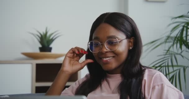 Mujer afroamericana sonriendo hablando en un video chat en un portátil — Vídeos de Stock