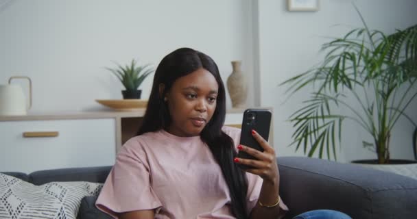 Mujer afroamericana hablando por videollamada en móvil, sosteniendo el teléfono en la mano — Vídeos de Stock