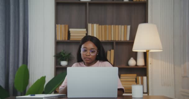 Afroamerykanka kończy pracę zdejmując okulary i zamykając laptopa — Wideo stockowe