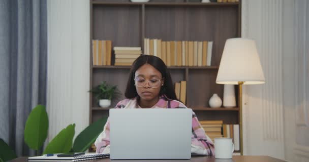 African american woman answer a call on a mobile phone while working on laptop — Stock Video