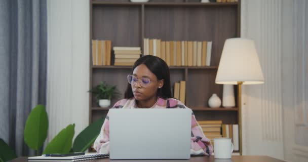 Femme afro-américaine répondre à un appel sur un téléphone portable tout en travaillant sur ordinateur portable — Video