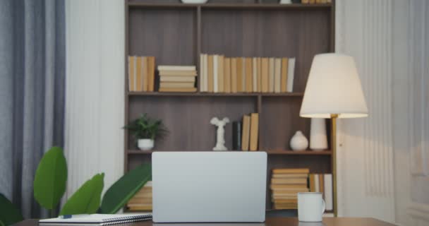 Ein schön eingerichteter Arbeitsplatz mit offenem Laptop, Becher und Notizblock — Stockvideo