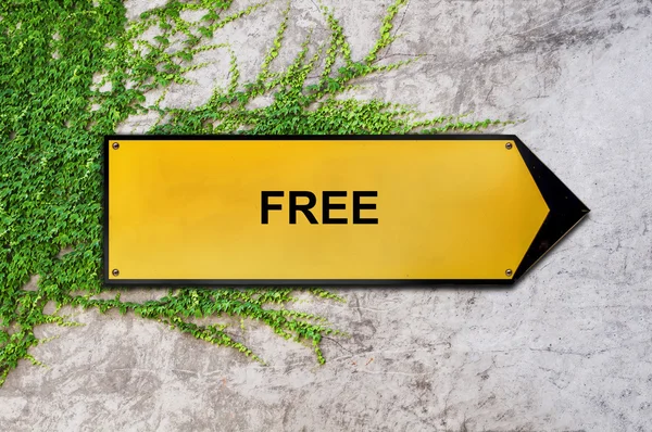 Free on yellow sign hanging on ivy wall — Stock Photo, Image