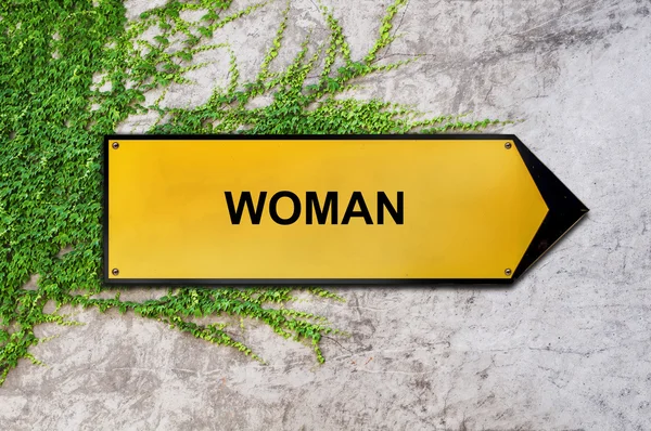 Frau auf gelbem Schild hängt an Efeu-Wand — Stockfoto