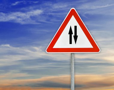 Üçgen işareti iki yönlü trafik çubuk ile bulutlu gökyüzü üzerinde