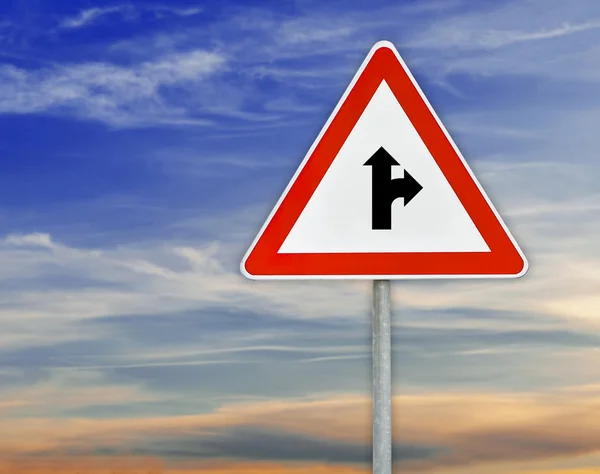 Triangle road sign the right direction on rod with cloudy sky — Stock Photo, Image