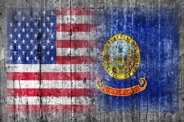 USA och Idaho flagga på betongvägg — Stockfoto