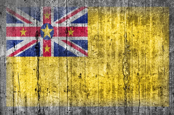 Niue flagga på betongvägg — Stockfoto
