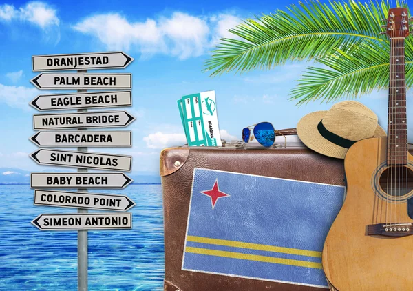 Concept of summer traveling with old suitcase and Aruba town sign — Stock Photo, Image