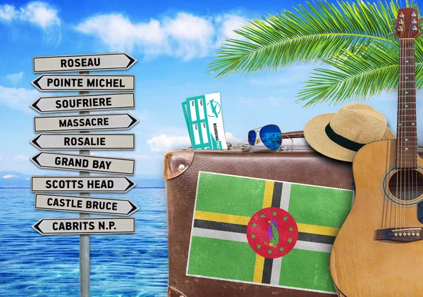 Begreppet sommaren reser med gammal resväska och Dominica staden tecken — Stockfoto