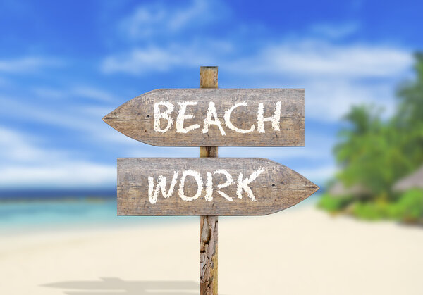 Wooden direction sign on beach or work