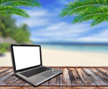 Dizüstü ekran üzerinde sahilde ahşap Bank
