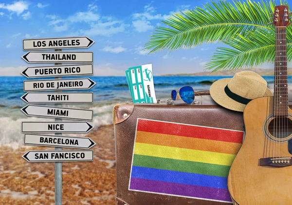 Концепция летнего путешествия со старым чемоданом и флагом ЛГБТ — стоковое фото