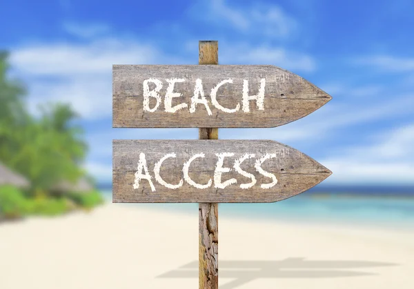 Wooden direction sign with beach access Stock Photo