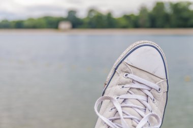 Göl arka plan üzerinde eski spor ayakkabı